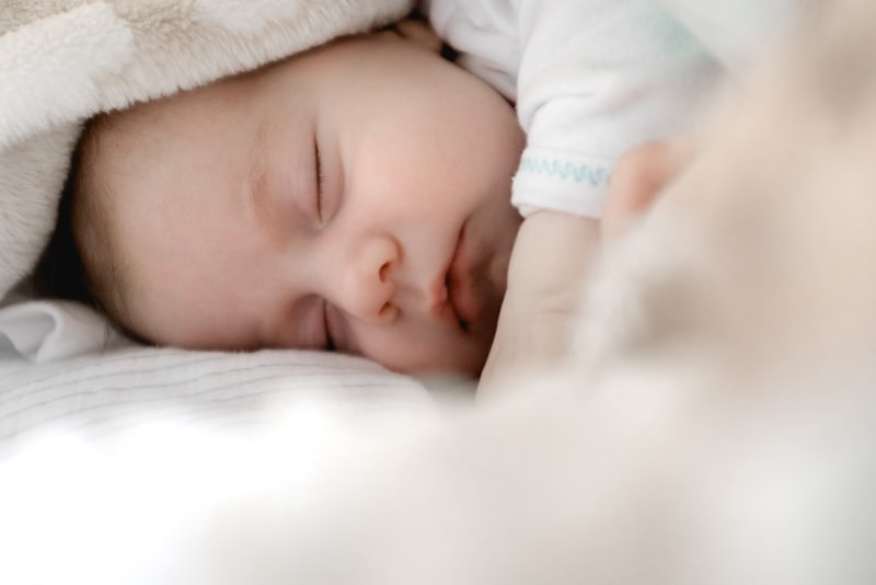 A packed overnight bag with baby clothes resting beside the front door